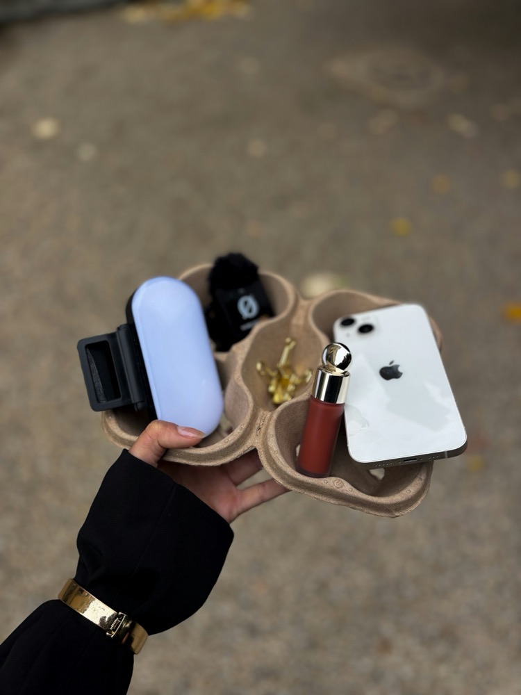 Flat lay of a phone, makeup, and accessories for a product post