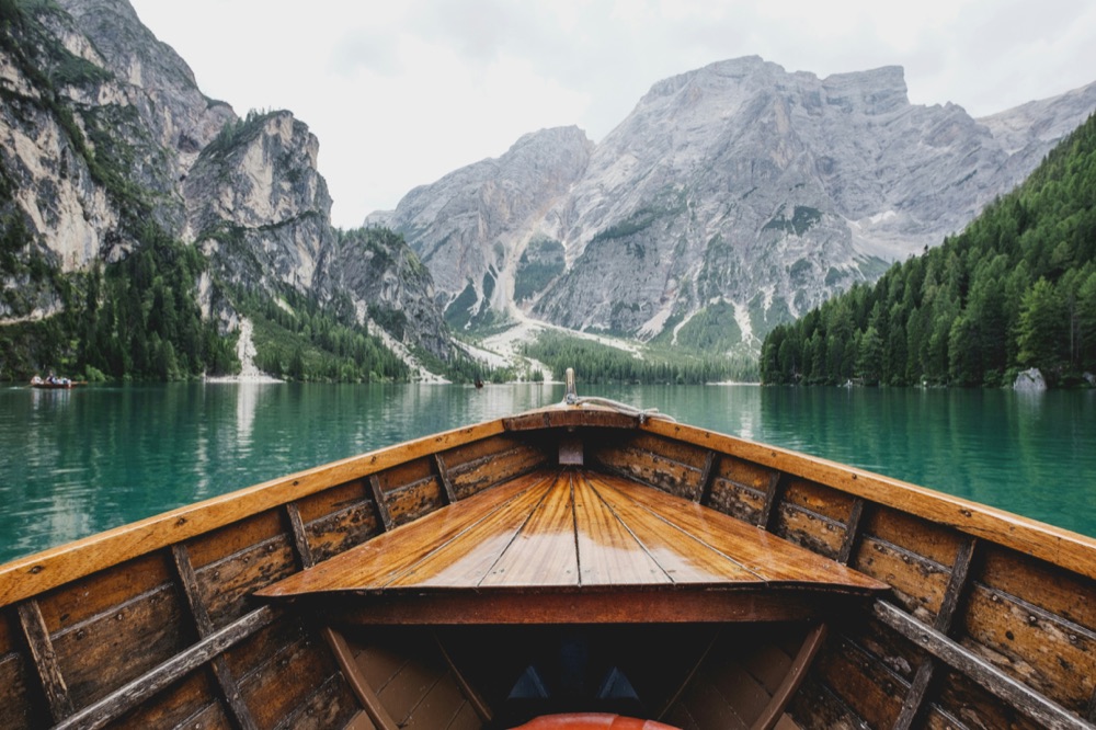 Boat crossing an alpine lake surrounded by mountains