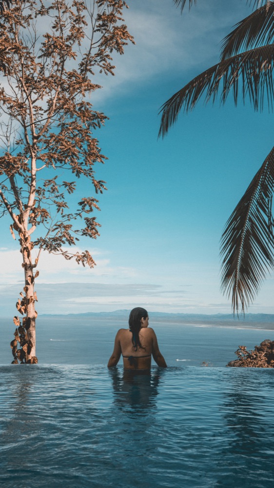 Creator relaxing in an infinity pool overlooking the ocean